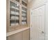Hallway with glass door cabinets and a full length door in neutral colors at 4001 Doves Roost Ct, Charlotte, NC 28211