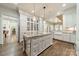 Bright kitchen featuring a large island, custom white cabinetry, hardwood floors, and stainless steel appliances at 4001 Doves Roost Ct, Charlotte, NC 28211