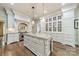 Gourmet kitchen with a large central island, custom white cabinetry, and stainless steel appliances at 4001 Doves Roost Ct, Charlotte, NC 28211