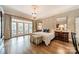 Elegant bedroom with hardwood floors, french doors, decorative wallpaper, and chandelier lighting at 4001 Doves Roost Ct, Charlotte, NC 28211