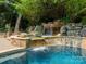Beautiful backyard pool featuring a stone waterfall, and lush landscaping at 4001 Doves Roost Ct, Charlotte, NC 28211