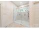 Modern walk-in shower with glass enclosure, neutral tile, and dual shower heads at 4001 Doves Roost Ct, Charlotte, NC 28211