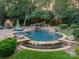 Luxurious swimming pool featuring a waterfall feature, stone accents, and lush landscaping for ultimate relaxation at 4001 Doves Roost Ct, Charlotte, NC 28211