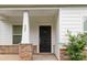 Inviting covered porch with decorative stone accents at the entry, address, and dark front door at 422 Nixon Rd, Belmont, NC 28012