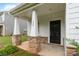 Inviting covered porch with decorative stone accents at the entry, address, and dark front door at 422 Nixon Rd, Belmont, NC 28012