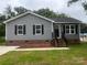 Charming home with gray siding, black shutters, brick foundation and landscaped front yard at 506 Locust St, Rock Hill, SC 29730