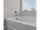 Close-up view of a large white bathtub with a chrome faucet and window at 5668 Stanfield Ridge Dr, Stanfield, NC 28163
