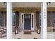Inviting front porch with brick facade, dark shutters, and a welcoming entrance and decorative lanterns at 5668 Stanfield Ridge Dr, Stanfield, NC 28163