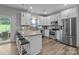 A bright kitchen featuring stainless steel appliances, an island with seating, and a sliding glass door at 5668 Stanfield Ridge Dr, Stanfield, NC 28163