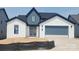 Modern two-story home with white brick, black roof, blue trim, and a two-car garage at 612 Hyder Trl, Tega Cay, SC 29708