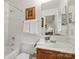 Bright bathroom features a shower over tub and a traditional vanity with a framed mirror at 626 Trail Ridge Rd, Matthews, NC 28105