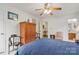 Bedroom with natural lighting, a queen sized bed, storage cabinet, and ceiling fan at 626 Trail Ridge Rd, Matthews, NC 28105