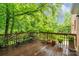 Outdoor deck with wood railings, comfortable chairs, and view of mature landscaping at 626 Trail Ridge Rd, Matthews, NC 28105