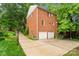 Back exterior of brick home featuring a driveway and two-car garage at 626 Trail Ridge Rd, Matthews, NC 28105