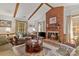 Bright living room showcasing a brick fireplace, wood beams, and comfortable seating at 626 Trail Ridge Rd, Matthews, NC 28105