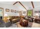 Spacious living room with a fireplace, sofa, wood beams and a view from the window at 626 Trail Ridge Rd, Matthews, NC 28105