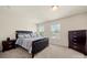 A bedroom featuring a tufted headboard bed frame, two side tables, and two windows for great natural light at 6510 Nathan Dr # 78, Charlotte, NC 28269