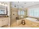 Elegant bathroom featuring a frameless glass shower, soaking tub, and neutral tile at 738 Rocky Hollow Trl, Clover, SC 29710
