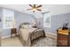 Bedroom with gray-blue walls, metal bed frame, and natural light from three windows at 738 Rocky Hollow Trl, Clover, SC 29710