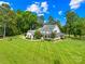 Stunning two-story farmhouse with a wrap-around porch and lush landscaping at 738 Rocky Hollow Trl, Clover, SC 29710