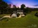 Beautiful two-story farmhouse with inviting wrap-around porch at dusk at 738 Rocky Hollow Trl, Clover, SC 29710