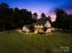 Beautiful two-story farmhouse with inviting wrap-around porch at dusk at 738 Rocky Hollow Trl, Clover, SC 29710