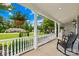 Inviting front porch with white railing, hanging ferns, rocking chairs, and a view of the manicured front lawn at 738 Rocky Hollow Trl, Clover, SC 29710