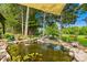 Backyard Koi pond with rock border, water feature, and lush greenery at 738 Rocky Hollow Trl, Clover, SC 29710