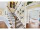 Charming staircase with carpeted steps, white banisters, and decorative artwork along the wall leading upstairs at 738 Rocky Hollow Trl, Clover, SC 29710
