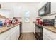 Well-lit kitchen with stainless steel sink, granite countertops, white cabinets, and black appliances at 8005 Stevie Oaks Ln, Charlotte, NC 28215