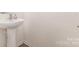 Small powder room featuring pedestal sink and tiled floors at 8005 Stevie Oaks Ln, Charlotte, NC 28215