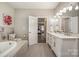 Neutral bathroom boasts double vanity, soaker tub, and a view of the bedroom at 8418 Knollwood Cir, Charlotte, NC 28213