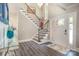 Elegant foyer features a staircase with wrought iron railings, chandelier, and ample natural light at 8418 Knollwood Cir, Charlotte, NC 28213