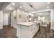 A kitchen island features a quartz countertop with a stainless undermount sink, along with hardwood flooring at 8418 Knollwood Cir, Charlotte, NC 28213
