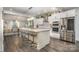 Bright kitchen features a large island with bar stool seating, stainless steel appliances, and hardwood flooring at 8418 Knollwood Cir, Charlotte, NC 28213