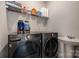 Efficient laundry room featuring washer, dryer, utility sink, and storage shelf at 8418 Knollwood Cir, Charlotte, NC 28213