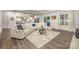 Bright living room featuring a white leather sofa, hardwood floors, and a view into the kitchen at 8418 Knollwood Cir, Charlotte, NC 28213