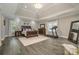 Spacious main bedroom features wood floors, a trey ceiling, a chandelier, and a treadmill at 8418 Knollwood Cir, Charlotte, NC 28213