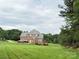 Back exterior elevation of home with backyard and partial treeline at 8620 Rolling Fields Rd, Charlotte, NC 28227