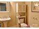 Cozy powder room features a pedestal sink, cabinet, and matching fixtures at 8620 Rolling Fields Rd, Charlotte, NC 28227
