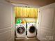 Open laundry room with washer, dryer, and upper cabinets at 8620 Rolling Fields Rd, Charlotte, NC 28227