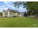 View of a verdant backyard with lush lawn, a white picket fence and mature landscaping at 9210 Ginhouse Ln, Charlotte, NC 28277