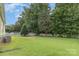 Spacious backyard with lush grass, white picket fence, and mature trees at 9210 Ginhouse Ln, Charlotte, NC 28277