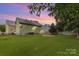 Verdant backyard showcases lush lawn, white picket fence, and mature landscaping at 9210 Ginhouse Ln, Charlotte, NC 28277