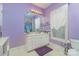 Bathroom with purple walls, white cabinets, and an ornate mirror at 9210 Ginhouse Ln, Charlotte, NC 28277