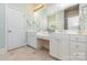 Bright bathroom featuring double sinks, vanity, and a door into a walk-in shower at 9210 Ginhouse Ln, Charlotte, NC 28277