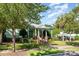 A charming green home with a cozy porch and bikes parked out front at 9210 Ginhouse Ln, Charlotte, NC 28277