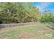 Beautiful yard with mature trees enclosed by a classic wood fence at 10726 Greenhead View Rd, Charlotte, NC 28262