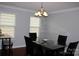 Bright dining room features a stylish chandelier and glass table with seating for four at 10726 Greenhead View Rd, Charlotte, NC 28262