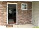 Exterior entrance showing a stone facade with a storm door leading into the home at 10726 Greenhead View Rd, Charlotte, NC 28262